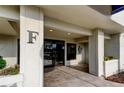 Building entrance with letter F above the doorway, tile flooring, and plants at 2323 Feather Sound Dr # F101, Clearwater, FL 33762