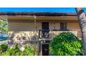 A close exterior view of a tan condo building with dark wood doors and green bushes at 2685 Sabal Springs Cir # 201, Clearwater, FL 33761