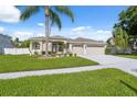 Well-maintained home with a lush green lawn, freshly painted driveway, and tropical palm tree landscaping at 2816 Pankaw Ln, Valrico, FL 33596