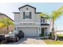 Inviting two-story home with a paved driveway and lush landscaping at 3047 Adams Cross Dr, Zephyrhills, FL 33540