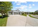 Attractive home featuring a spacious driveway, three-car garage, and well-maintained front yard at 3159 Marisa Pl, Holiday, FL 34691