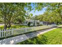 Inviting single-story home with a white picket fence and beautiful mature shade trees at 317 N Washington Ave, Clearwater, FL 33755