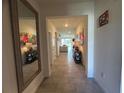 Hallway with neutral tile flooring connects to the main living area and features decorative shelving at 33034 Sand Creek Dr, Wesley Chapel, FL 33543