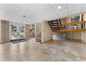 A well-lit lobby with tile floors, a brick accent wall, staircase, and glass entrance doors at 36750 Us 19 N # 24-104, Palm Harbor, FL 34684