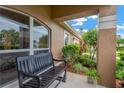 Inviting front porch with a comfortable bench, potted plant, and neatly trimmed bushes at 3913 Little Egret Ct, Lutz, FL 33558
