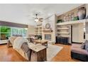 Open-concept living room features a brick fireplace, wood floors, and large windows at 3913 Little Egret Ct, Lutz, FL 33558