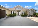 Inviting home with stone facade, manicured landscaping, and a front entrance with double doors at 5325 San Remo Cir, Wimauma, FL 33598