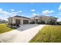 Spacious home with an extra-long driveway, three-car garage, stone accents, and lush landscaping at 5325 San Remo Cir, Wimauma, FL 33598