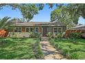 Beautiful single-story home featuring a well-manicured lawn and a pathway leading to the front door at 6213 10Th S Ave, Gulfport, FL 33707