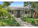 Charming single-story home with well-kept lawn, garden beds, and a stone walkway leading to the decorative front door at 6213 10Th S Ave, Gulfport, FL 33707