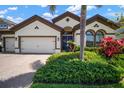 Beautiful home featuring lush landscaping, a paver driveway, and a stately blue front door at 6307 Salt Creek Ave, Apollo Beach, FL 33572