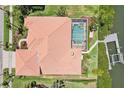 Aerial view showcases the home's terracotta roof, screened pool, and waterfront location with boat dock at 6461 Rubia Cir, Apollo Beach, FL 33572