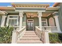 Elegant front entrance with stately columns, brick stairs, and sophisticated architectural details at 6461 Rubia Cir, Apollo Beach, FL 33572