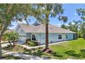 Beautiful single-story home with stone accents, lush landscaping, and a well-manicured lawn on a sunny day at 7413 Surrey Wood Ln, Apollo Beach, FL 33572