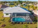Backyard aerial view featuring screened in pool with manicured yard, landscaping, and neighborhood at 7504 Carissa, Punta Gorda, FL 33955