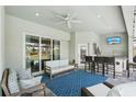 Cozy outdoor living area with comfortable seating, ceiling fan, bar, and sliding glass doors at 7504 Carissa, Punta Gorda, FL 33955
