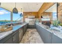 Stylish outdoor kitchen with stainless steel appliances, granite countertops, and a lovely waterfront view at 915 Bayshore Dr, Tarpon Springs, FL 34689