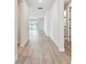 Bright hallway featuring wood floors leading to the living areas and bathroom at 11834 Mile Marsh Dr, Riverview, FL 33569