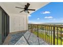 Balcony with views of the ocean and tennis courts with metal railing and a ceiling fan at 1230 Gulf Blvd # 508, Clearwater Beach, FL 33767