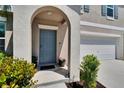 Close up of front door, arched alcove, and tidy landscaping at 13234 Great Plains Dr, Riverview, FL 33579