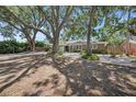 Inviting single-story home with a stone exterior and landscaped front yard featuring mature trees at 1557 Robinson N Dr, St Petersburg, FL 33710