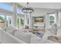 Bright living room with floor-to-ceiling windows, a modern chandelier, and white furniture at 19 Crescent S Pl, St Petersburg, FL 33711