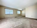 Expansive living room with neutral carpet, ceiling fan, and large windows at 203 Rickenbacker Dr, Sun City Center, FL 33573