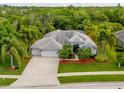 Stunning aerial view of a charming home with mature palm trees, lush landscaping, and a spacious driveway at 211 Royal Bonnet Dr, Apollo Beach, FL 33572