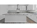 Bright kitchen with white cabinets, stainless steel appliances, granite countertops and island at 3612 W Pearl Ave, Tampa, FL 33611