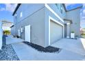 Exterior shot showing the side of the home, the two-car garage, walkway lined with river rock, and electrical panel at 36454 Flats St, Zephyrhills, FL 33541