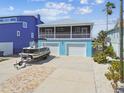 Charming two-story home featuring a screened-in porch, a two-car garage, and a boat on a trailer in the driveway at 4039 Casa Ct, Hernando Beach, FL 34607