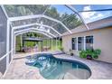 A screened-in pool area with a gazebo and outdoor seating, perfect for relaxing at 5114 Whispering Leaf Trl, Valrico, FL 33596