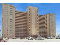View of the condo building's exterior with multiple stories and a parking lot in front against a blue sky at 5200 Brittany S Dr # 1807, St Petersburg, FL 33715
