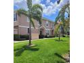 Two-story townhome with manicured lawn, lush tropical foliage, and a private entrance at 584 52Nd N Ave, St Petersburg, FL 33703