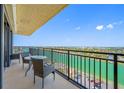 This condo balcony features a table and chairs, providing a relaxing space to enjoy scenic views of the waterfront at 7600 Bayshore Dr # 1206, Treasure Island, FL 33706