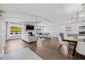 Open-concept living space with fireplace, modern furnishings, hardwood flooring, and updated kitchen in background at 8335 Fountain Ave, Tampa, FL 33615