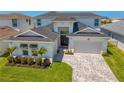 Attractive front view featuring a well-manicured lawn, a two-car garage, and a double-door entrance at 8346 Ivy Stark Boulevard, Wesley Chapel, FL 33545