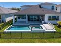 Backyard pool and hot tub featuring lounge chairs, a covered patio, and a fenced-in yard at 8346 Ivy Stark Boulevard, Wesley Chapel, FL 33545