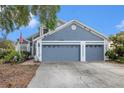 Charming home featuring a spacious three-car garage, well-maintained landscaping, and a welcoming front facade at 8704 Tarrington Pl, Tampa, FL 33635