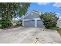 Charming home featuring a spacious three-car garage, well-maintained landscaping, and a welcoming front facade at 8704 Tarrington Pl, Tampa, FL 33635