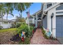 Inviting home exterior, showcasing a brick walkway, flagpole, and colorful landscaping, offering curb appeal at 8704 Tarrington Pl, Tampa, FL 33635