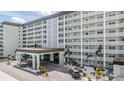 Elegant condo building showcasing intricate balcony designs, enhanced by a porte cochere and lush landscaping at 9 Forbes Pl # 205, Dunedin, FL 34698