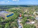 Expansive aerial view of estate home with lush landscape, pond, and surrounding trees at 9520 Indale Dr, New Port Richey, FL 34654