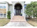 Elegant front entrance with double doors, brick steps, and decorative columns at 9520 Indale Dr, New Port Richey, FL 34654