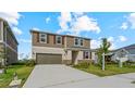Two-story home featuring a two-car garage, neutral siding, shuttered windows, and landscaped front yard at 9567 Sandy Bluffs Cir, Parrish, FL 34219