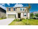 Two-story home with neutral siding, shuttered windows, two-car garage, and landscaped front yard on a sunny day at 9567 Sandy Bluffs Cir, Parrish, FL 34219