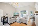 Bright living room featuring vaulted ceilings, comfortable seating, and sliding glass doors to the pool area at 10021 Elgin Blvd, Spring Hill, FL 34608