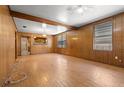 Spacious living room with wood-paneled walls, and light hardwood floors at 1205 E Emma St, Tampa, FL 33603