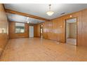 Open living room featuring wood-paneled walls, and light hardwood floors at 1205 E Emma St, Tampa, FL 33603