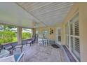 Relaxing covered patio with tile flooring, ceiling fan, and comfortable seating at 1211 Golfview Woods Dr, Sun City Center, FL 33573